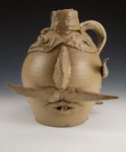 A collaborative piece by McCarthy and a student, Ben Z., made as a modern reinterpretation of face jugs. Wheel-thrown stoneware, altered, wood-fired to Cone 10, salt-glazed, 13.5 x 10 x 9 in.